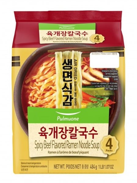 Spicy beef flavored ramen noodle soup package with noodles and vegetables on a yellow background